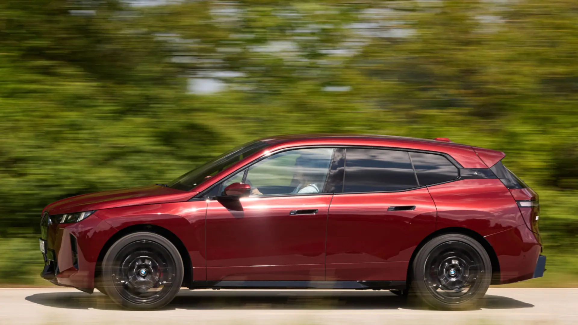 BMW iX xDrive45 électrique gris vue de trois-quarts avant sur route, SUV premium de 408 chevaux