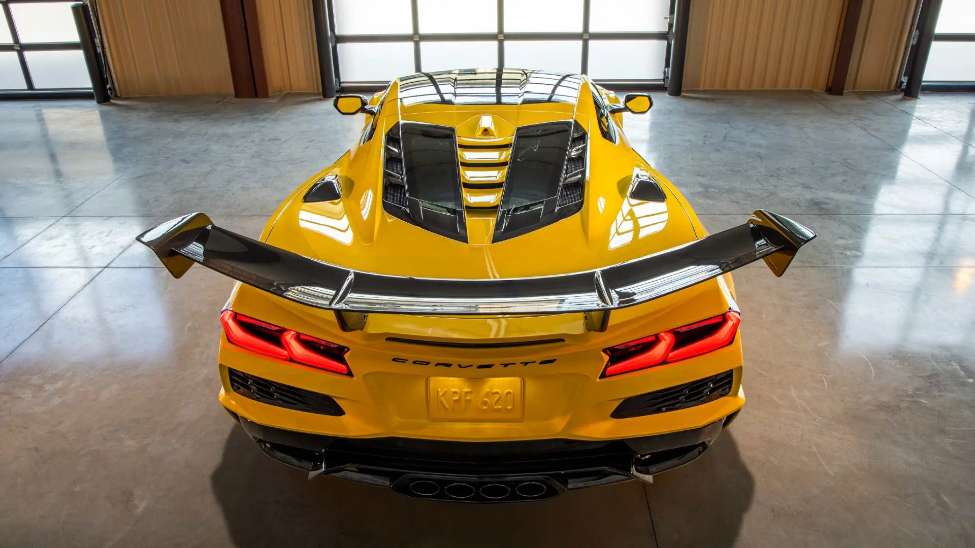 Corvette ZR1 blanche avec aileron arrière en carbone montrant des écaillages de peinture aux points d'ancrage