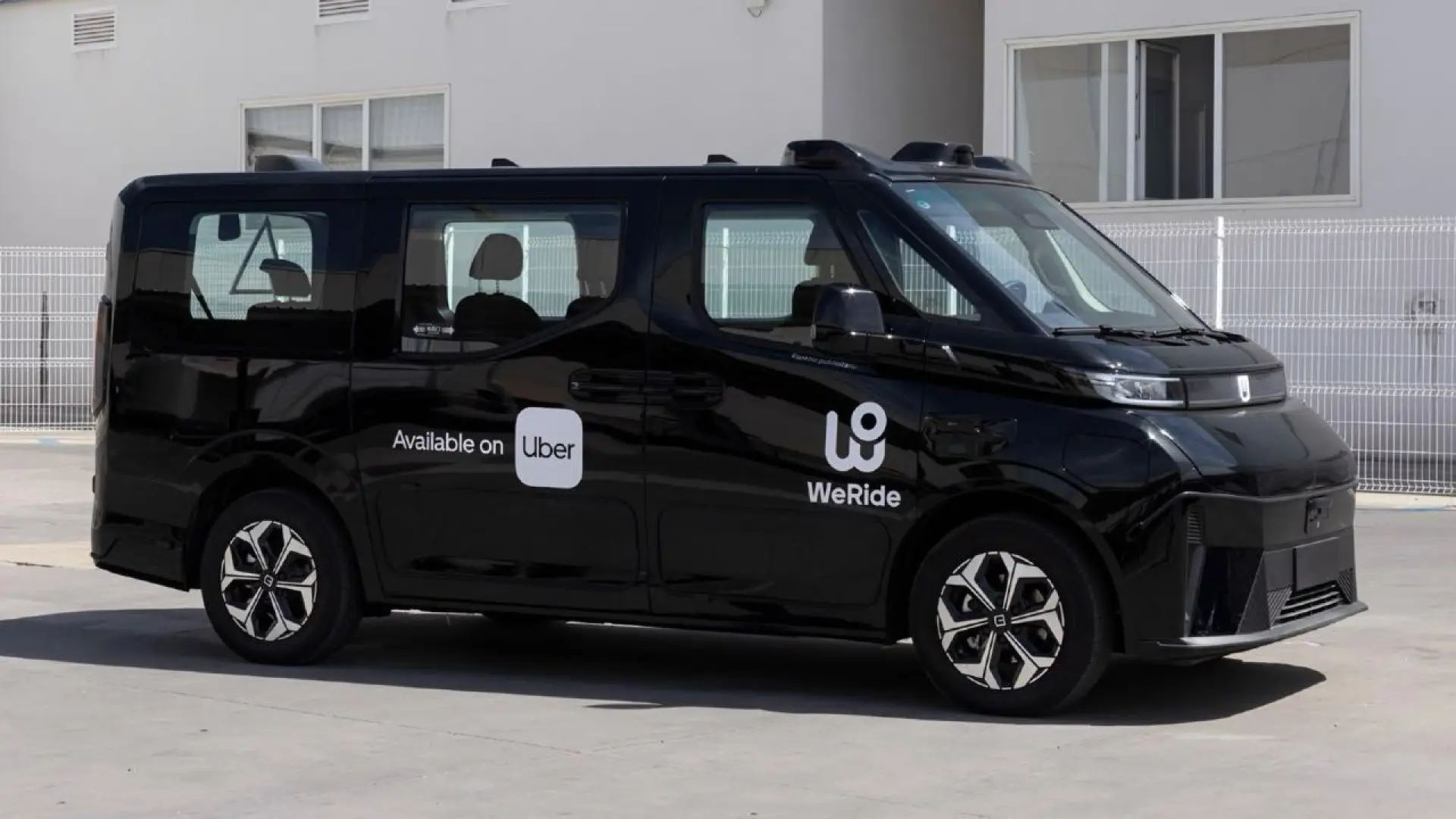 Robotaxi autonome blanc circulant dans une rue de Madrid avec capteurs et technologies de conduite autonome